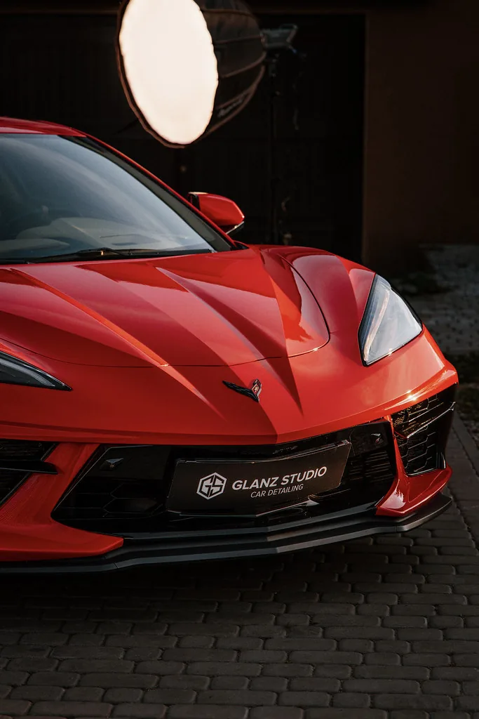 Przód Corvette C8 podczas sesji przy lampie studyjnej, lakier odbija światło jak lustro